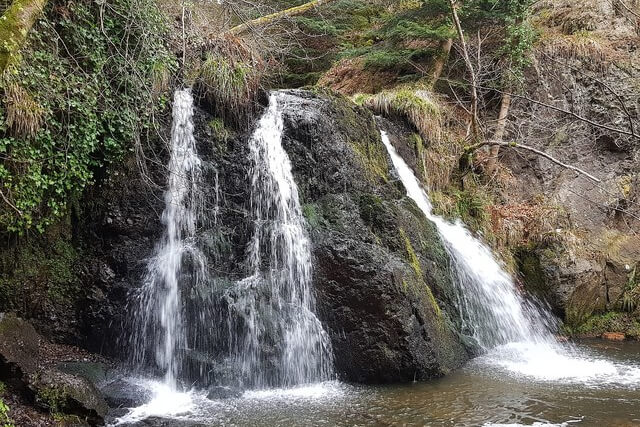 A waterfall cascasing down a rockface at The Fairy Glen 