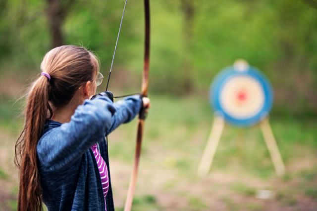 Young girl having a go at archery