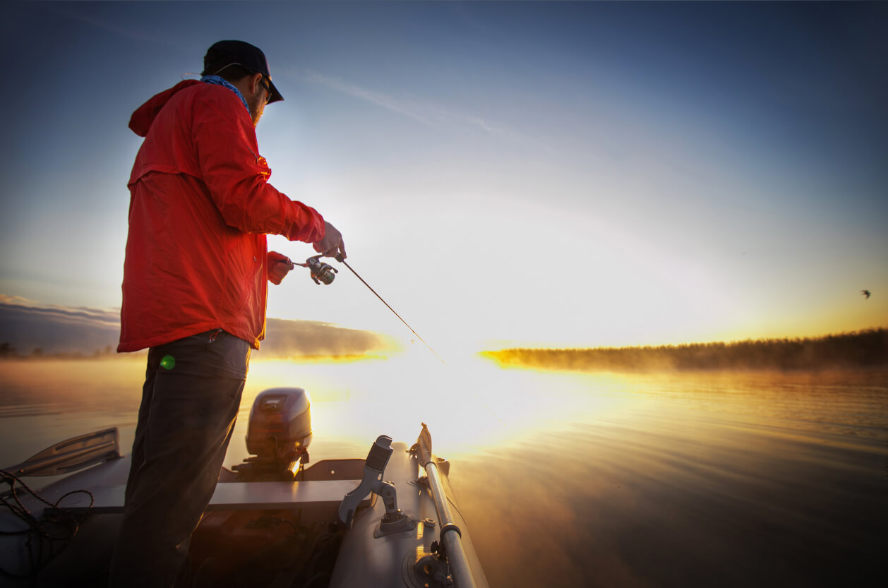 man fishing in large body of water off a boat